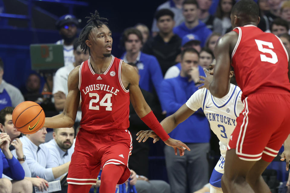 Louisville's Jae'Lyn Withers (24) looks for a teammate as Kentucky's Adou Thiero (3) defends during the first half of an NCAA college basketball game in Lexington, Ky., Saturday, Dec. 31, 2022. (AP Photo/James Crisp)