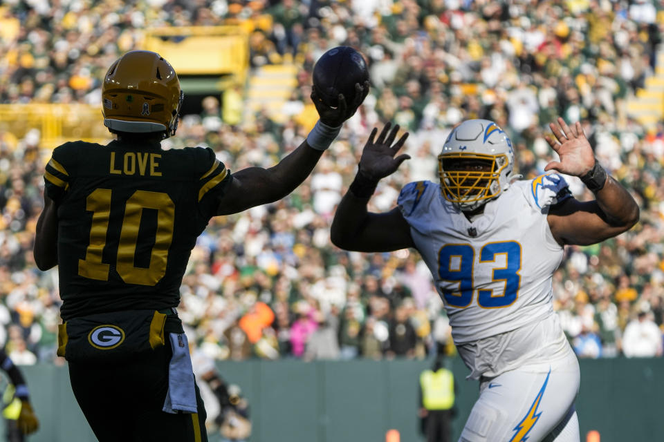 Green Bay Packers quarterback Jordan Love (10) attempts a pass as Los Angeles Chargers defensive tackle Otito Ogbonnia (93) applies pressure during the first half of an NFL football game, Sunday, Nov. 19, 2023, in Green Bay, Wis. (AP Photo/Morry Gash)