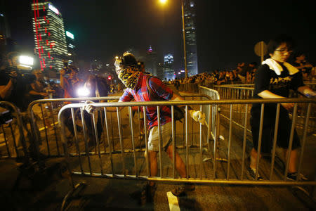 A protester carries a metal fence as he tries to block an avenue outside the offices of Hong Kong's Chief Executive Leung Chun-ying in Hong Kong October 2, 2014. REUTERS/Carlos Barria