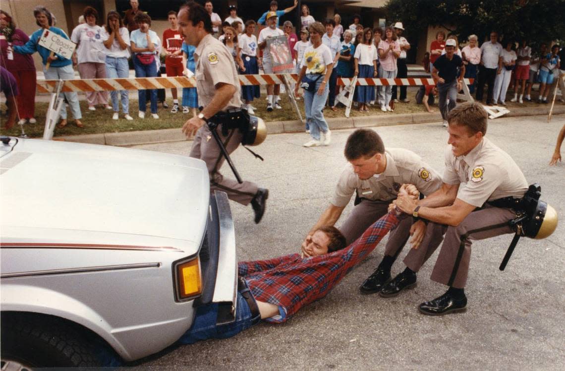 Wichita Police officers attempted to remove an abortion protester from under a car at the entrance to Dr. George Tiller’s clinic during the Summer of Mercy protest in 1991.