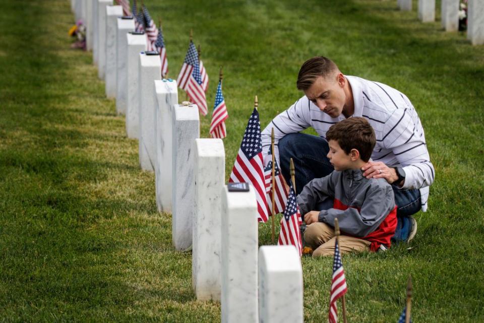 Brad Fromm talks to his son, Tyler, at the final resting place of a fallen loved one in Arlington National Cemetery on Memorial Day.