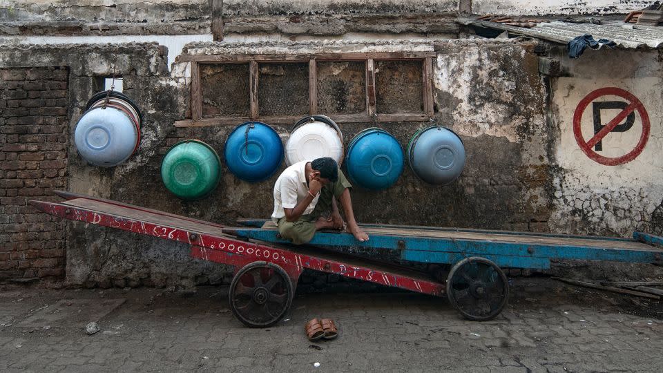 A worker watches his mobile phone while taking a break in Mumbai on April 17, 2024. - Noemi Cassanelli/CNN