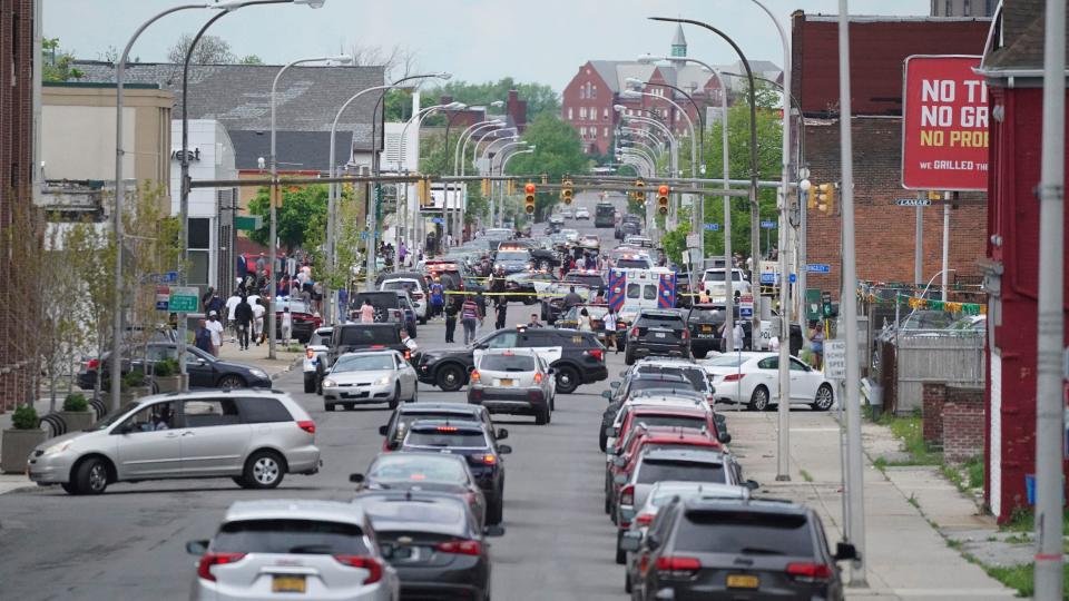 Police vehicles block off the street where at least 10 people were killed in a shooting at a supermarket, Saturday, May 14, 2022 in Buffalo, N.Y. Officials said the gunman entered the supermarket with a rifle and opened fire. Investigators believe the man may have been livestreaming the shooting and were looking into whether he had posted a manifesto online (Derek Gee/The Buffalo News via AP)