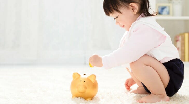 Toddler and piggy bank