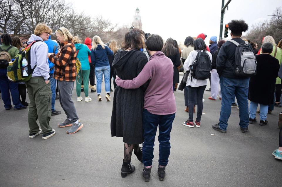 Isabella DeJoseph, 15, center left, is embraced by her mother Alana as they leave East High School after a school shooting, Wednesday, March 22, 2023, in Denver.