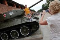 A child has his picture taken on top of a a Soviet-style tank displayed at Kremlin in Nizhny Novgorod, Russia, June 30, 2018. REUTERS/Damir Sagolj