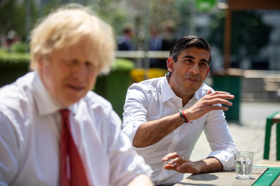 Britain's Prime Minister Boris Johnson (L) and Britain's Chancellor of the Exchequer Rishi Sunak (R) visit Pizza Pilgrims in West India Quay, London Docklands on June 26, 2020 as the restaurant prepares to reopen on July 4 as coronavirus lockdown rules are eased. - The British government on Thursday unveiled plans to get the public out of indoor confinement and on to the streets to boost the economy after three months of coronavirus lockdown. Prime Minister Boris Johnson wants pubs and restaurants to be buzzing in the curtailed summer season, despite continued social distancing rules and restrictions. (Photo by Heathcliff O'Malley / POOL / AFP) (Photo by HEATHCLIFF O'MALLEY/POOL/AFP via Getty Images)