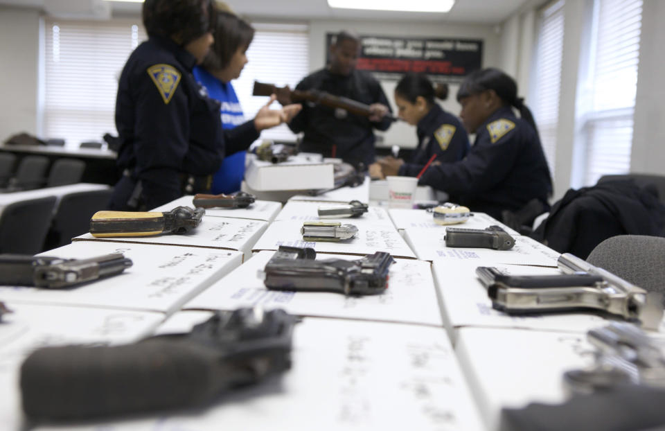 New Haven police officers catalogue guns being turned in during a gun buyback event at the New Haven Police Academy in New Haven, Connecticut, December 22, 2012. The program, sponsored by the Injury Free Coalition for Kids of New Haven and Yale-New Haven Children's Hospital, offered gift cards in exchange for working guns. REUTERS/ Michelle McLoughlin (UNITED STATES - Tags: SOCIETY)