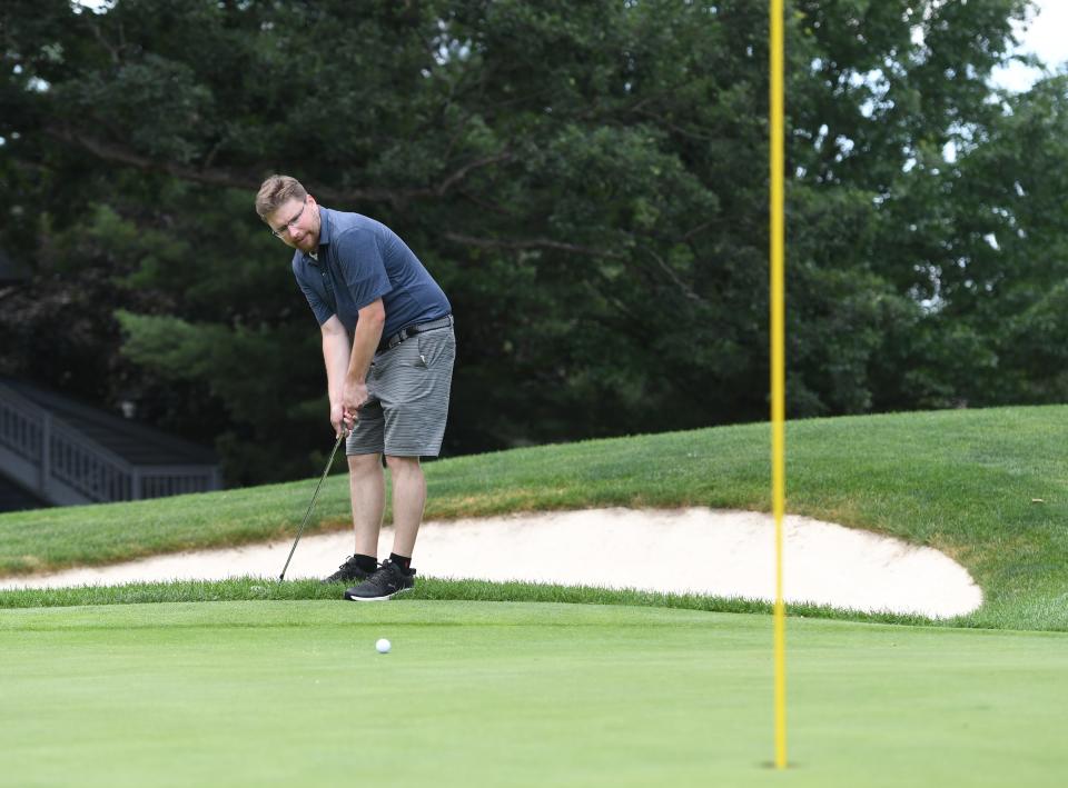 Ryan Lewis of the Akron Beacon Journal putts from the fringe on the 16th hole of Firestone Golf Club’s South Course on Monday in Akron.