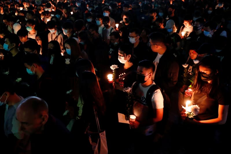 Students pay tribute with flowers to Chow Tsz-lok, 22, a university student who fell during protests at the weekend and died early on Friday morning, at the Hong Kong University of Science and Technology, in Hong Kong