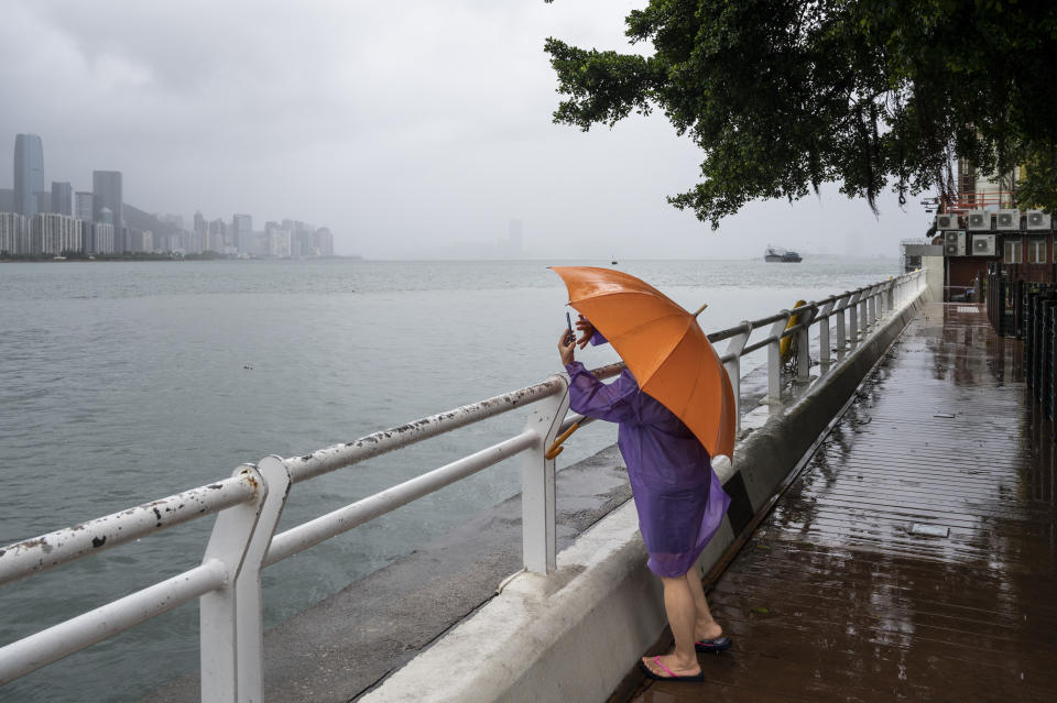 HONG KONG, CHINA - AUGUST 25: A woman takes pictures of the storm as Hong Kong prepares for the arrival of the severe tropical storm Ma-On, which sustained winds of 63 miles (101 kilometers) per hour and disrupted Thursday businesses and air travel as it reached T8 signal in the morning in Hong Kong, China on August 25, 2022. (Photo by Miguel Candela/Anadolu Agency via Getty Images)