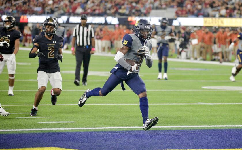 Warren receiver Jordan Ross scores a touchdown in the second quarter of Friday night's 28-21 victory over rival Downey.