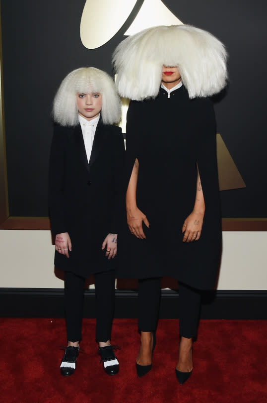 <p>The notoriously shy “Chandelier” singer and her mini-me Maddie Ziegler attended the Grammys together dressed in matching Armani looks. Each stood out from the other in little ways, with Sia in a custom cape, and Maddie wearing black and white brogues, but the overwhelming wigs connected them.</p>