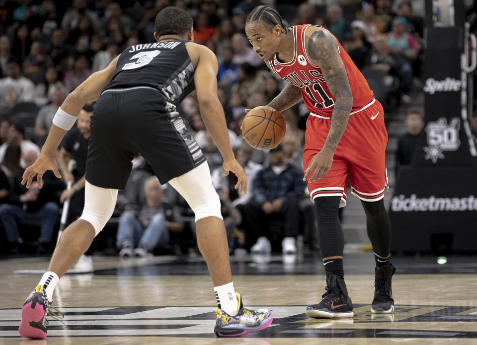 Chicago Bulls forward DeMar DeRozan (11) dribbles the ball as San Antonio Spurs forward Keldon Johnson (3) defends during the second half of an NBA basketball game, Friday, Oct. 28, 2022, in San Antonio. (AP Photo/Nick Wagner)