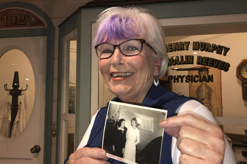Nurse practitioner Sigrid Stokes, 76, holds a photograph of her mother talking to Shirley Temple, at the Salinas Valley Memorial Hospital in Salinas, Calif., Wednesday, Feb. 3, 2021. Stokes is following in her family's footsteps during the pandemic. In 1918, Stokes' mother Kristine Berg Mueller was a 14-year-old hospital volunteer in Norway during the Spanish Flu pandemic, putting her in regular contact with the deadly disease. (AP Photo/Haven Daley)