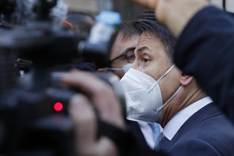 FILE - In this Jan 13, 2021 file photo, Italy's Prime Minister Giuseppe Conte is mobbed by reporters as he walks near Palazzo Chigi government headquarters, in Rome, Wednesday, Jan 13, 2021. Former premier Matteo Renzi is testing his already low popularity by provoking a political crisis that could bring down the government at yet another critical juncture in the fight against the pandemic. The outcome Renzi’s powerplay - orchestrating the resignations of two ministers from his tiny but key Italia Viva party - will play out this week, when Premier Giuseppe Conte addresses both houses of Parliament in a bid to win support and form what would be his third coalition government since elections in 2018. (AP Photo/Andrew Medichini)