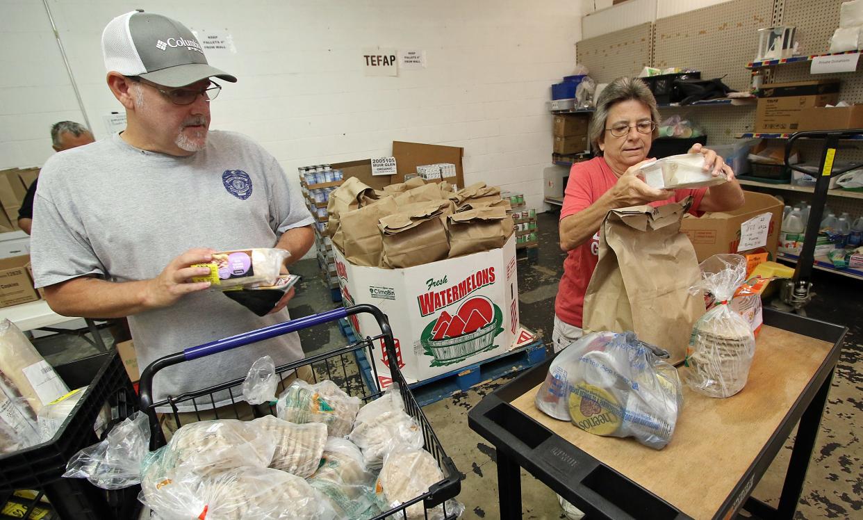 Volunteers Mark Fagala and Sam Sawyer work in the food pantry Thursday morning, July 27, 2023, at the Dallas High Shoals Christian Ministry on East Trade Street in Dallas.