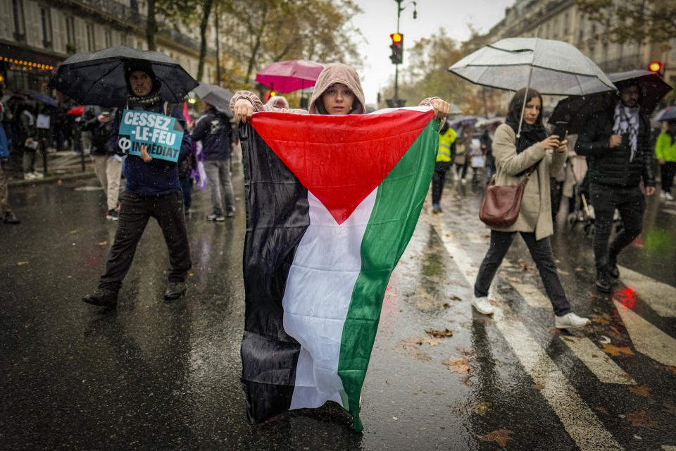 FILE - A woman holds a Palestinian flag during a pro-Palestinian rally, in Paris, on Nov. 18, 2023. Antisemitism is spiking across Europe after Hamas' Oct. 7 massacre and Israel's bombardment of Gaza, worrying Jews from London to Geneva and Berlin. (AP Photo/Thibault Camus, File)