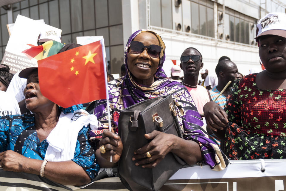 FILE - In this July. 21, 2018, file photo, a Senegal resident welcomes Chinese President Xi Jinping during his visit to Dakar, Senegal. China's loans to poor countries in Africa and Asia impose unusual secrecy and repayment terms that are hurting their ability to renegotiate debts after the coronavirus pandemic, a group of U.S. and German researchers said in a report Wednesday, March 31, 2021. (AP Photo/Xaume Olleros, File)