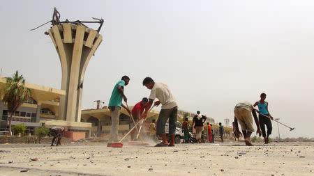 Workers remove debris from the international airport of Yemen's southern port city of Aden after Southern Resistance fighters took control of it July 15, 2015. REUTERS/Stringer