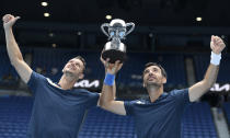 Croatia's Ivan Dodig, right, and Slovakia's Filip Polasek hold their trophy aloft after defeating Rajeev Ram of the US and Britain's Joe Salisbury in the men's doubles final at the Australian Open tennis championship in Melbourne, Australia, Sunday, Feb. 21, 2021.(AP Photo/Andy Brownbill)