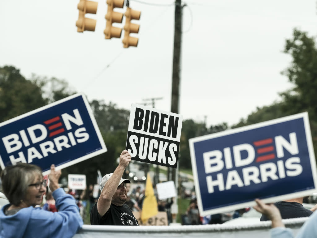  Pro-Biden and Pro-Trump supporters hold signs ahead of U.S. President Joe Biden's arrival in Howell, Michigan, in 2021. 