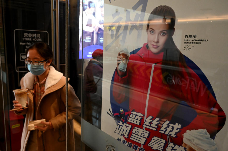 A woman walk past a poster showing China&#39;s US-born gold medallist Gu Ailing Eileen at a shopping mall in Beijing on February 12, 2022. / AFP PHOTO / Noel Celis (Photo by NOEL CELIS / AFP) (Photo by NOEL CELIS/AFP via Getty Images)