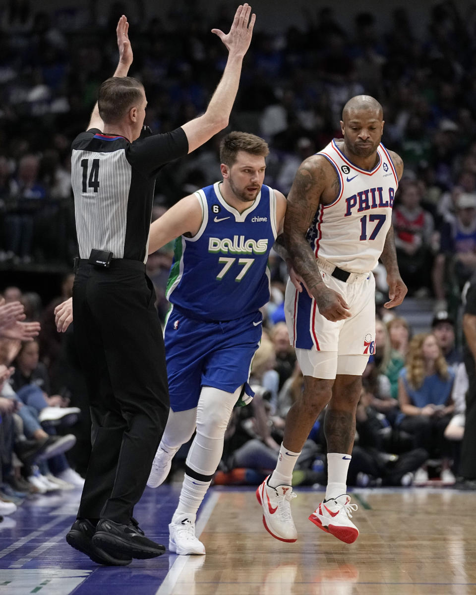 Dallas Mavericks' Luka Doncic (77) and Philadelphia 76ers' P.J. Tucker (17) run up court as referee Ed Malloy (14) signals following Doncic's three-point shot in the first half of an NBA basketball game, Thursday, March 2, 2023, in Dallas. (AP Photo/Tony Gutierrez)