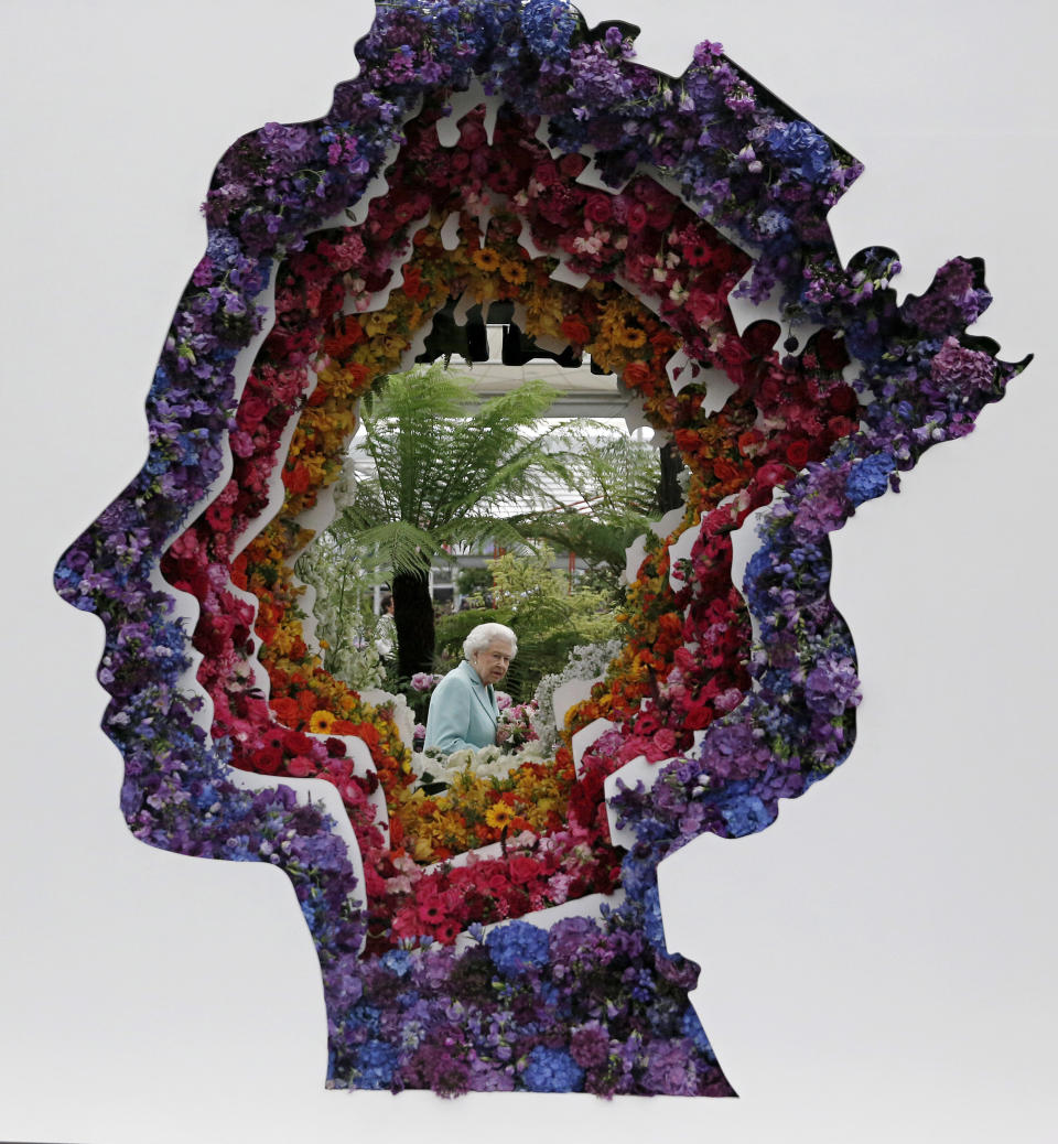 Britain's Queen Elizabeth is pictured through a gap in a floral exhibit by the New Covent Garden Flower Market, which features an image of the Queen, at the 2016 Chelsea Flower Show in central London, May 23, 2016. (Adrian Dennis/Pool Photo via AP)