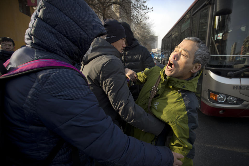 Plainclothes security officers take away a supporter of Chinese human rights lawyer Wang Quanzhang near the Secondary Intermediate People's Court of Tianjin northeastern China's Tianjin municipality, Wednesday, Dec. 26, 2018. The trial of Wang, who was charged with subversion of state power in 2016, was expected to begin at the court on Wednesday morning. (AP Photo/Mark Schiefelbein)