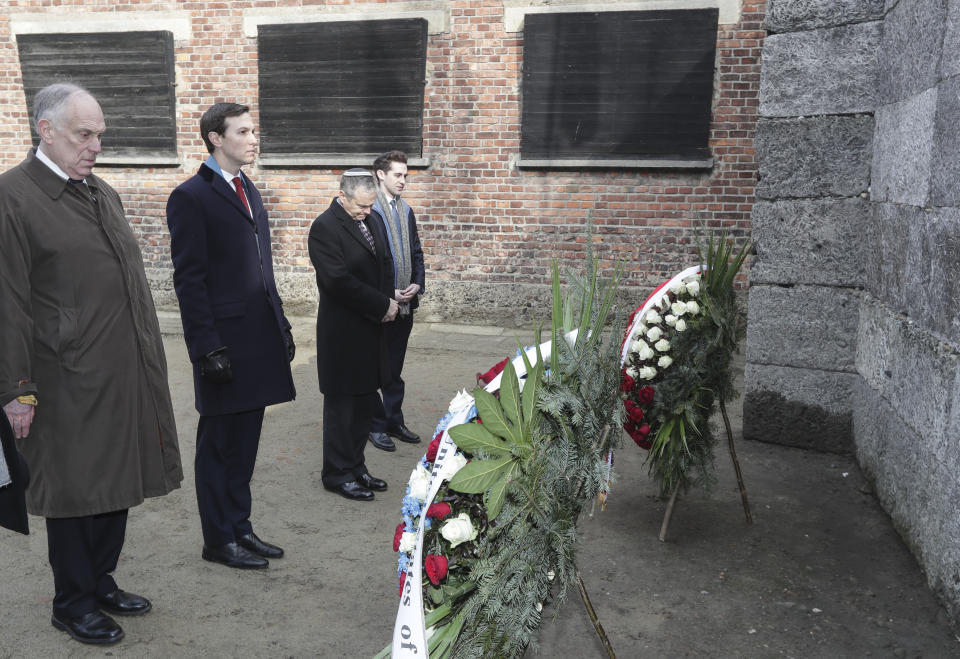 White House Senior Adviser Jared Kushner, 2nd from left, stands in front of wreaths at a death wall during a visit at the Nazi concentration camp Auschwitz-Birkenau in Oswiecim, Poland, Friday, Feb. 15, 2019. (AP Photo/Michael Sohn)