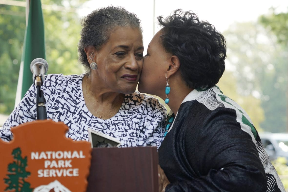 Myrlie Evers left, is kissed by her daughter Reena Evers-Everette, right, prior to the unveiling the new park sign for the Medgar and Myrlie Evers Home National Monument in Jackson, Miss., Thursday, June 8, 2023. (AP Photo/Rogelio V. Solis)
