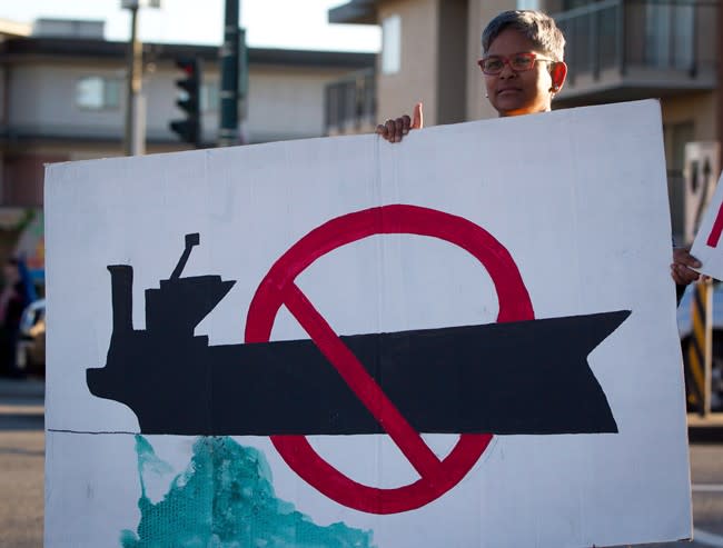 Fawzia Ahmad holds a sign as the group Communities Against Pipelines protests in Vancouver, B.C., on Friday October 5, 2012. Following months of hearings, years of debate and dozens of protests, the federal panel reviewing the controversial Northern Gateway pipeline will release its report later today.Much hangs in the balance.THE CANADIAN PRESS/Darryl Dyck