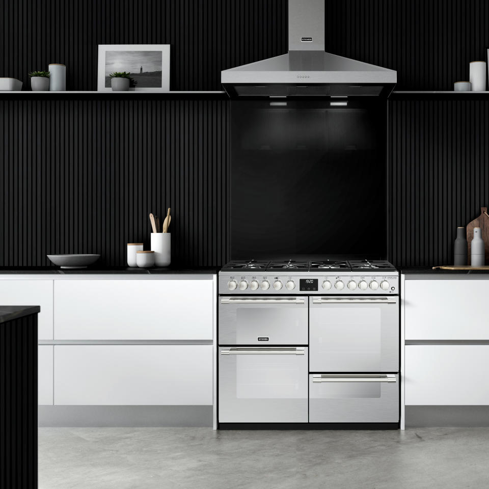 Modern white kitchen with black wall paneling and stainless steel appliances