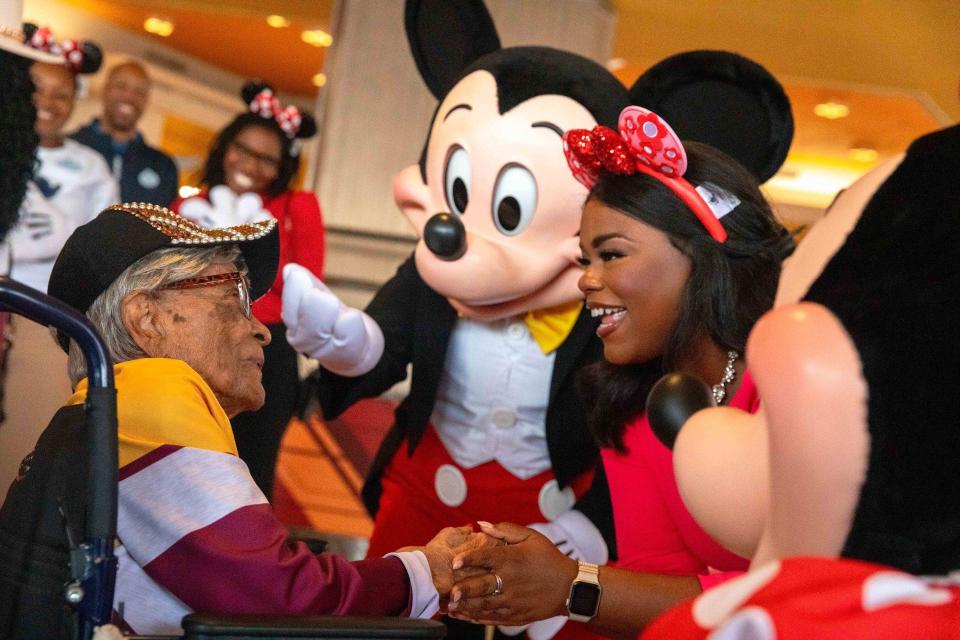 Magnolia Jackson, who wanted to celebrate her 106th birthday at Walt Disney World Resort in Lake Buena Vista, Fla., after seeing Mickey Mouse perform recently in his drum major uniform at a college football game, is warmly greeted Wednesday by Mickey Mouse and the Walt Disney World Ambassadors as she arrived at Magic Kingdom for the first time. Born March 14, 1918 and the oldest living graduate of Bethune-Cookman University in nearby Daytona Beach, Florida, Jackson was showered in birthday wishes and admiration by Disney cast members and executives before she went off to enjoy the parks, visiting with Princess Tiana and experiencing the EPCOT International Flower & Garden Festival. (Bennett Stoops, Photographer)