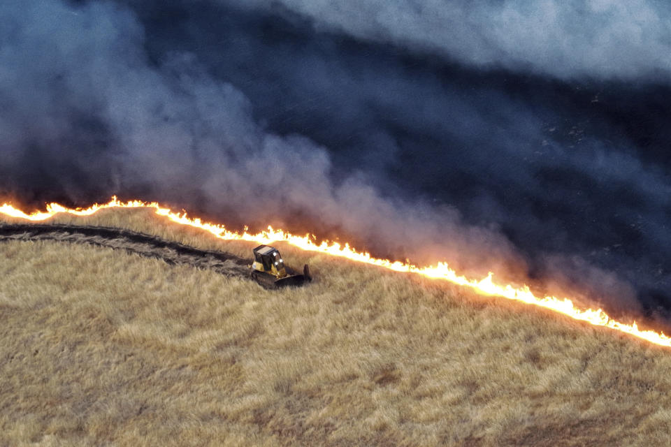 This photo released by the California Department of Forestry and Fire Protection shows a bulldozer working against the Corral Fire on Sunday, June 2, 2024, near Tracy, Calif. (California Department of Forestry and Fire Protection via AP)