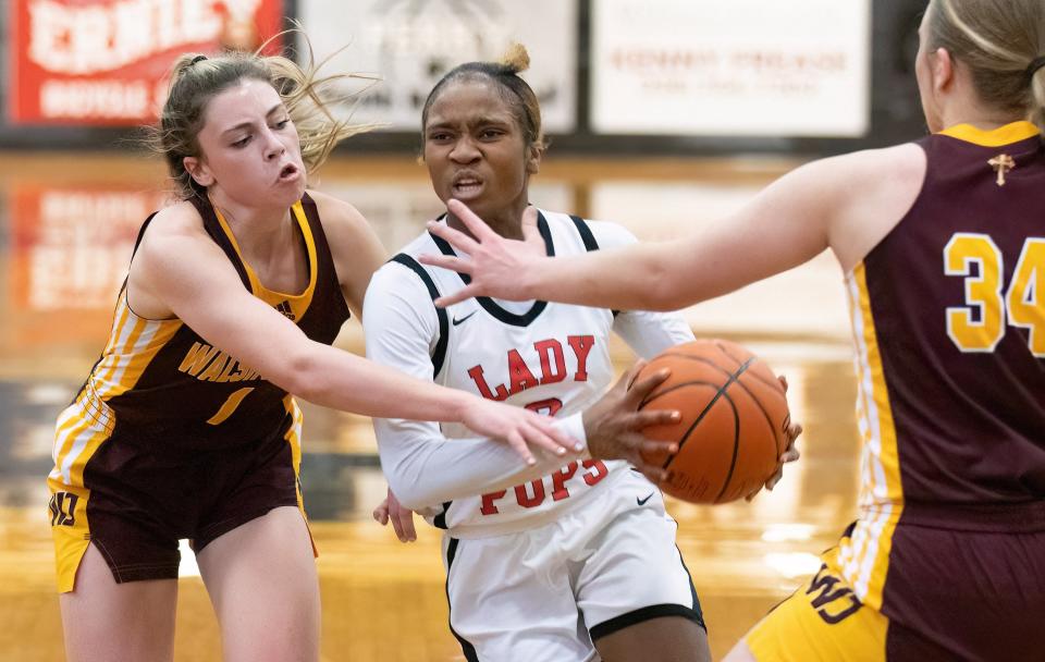 McKinley’s Paris Stokes drives between Walsh Jesuit’s defenders Cesily Sutton (1) and Taylor Angielski (34) during the Division I sectional final Friday, Feb. 24, 2023.