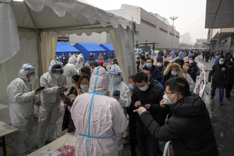 Medical workers scan codes on people's smartphones at a mass coronavirus testing site in Beijing, Monday, Jan. 24, 2022. Chinese authorities have lifted a monthlong lockdown of Xi'an and its 13 million residents as infections subside ahead of the Winter Olympics. Meanwhile, the 2 million residents of one Beijing district are being tested following a series of cases in the capital. (AP Photo/Andy Wong)