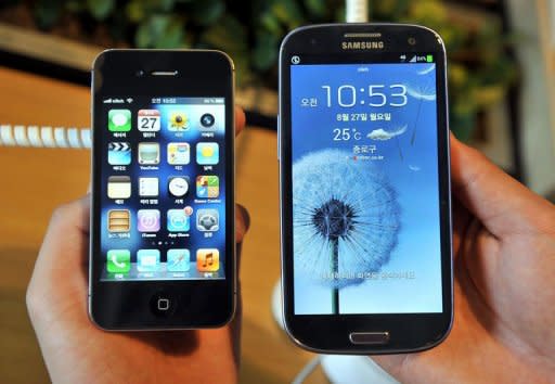 An employee shows an Apple's iPhone 4s (L) and a Samsung's Galaxy S3 (R) at a mobile phone shop in Seoul on August 27, 2012. A jury in San Jose, California decided Friday that Samsung "wilfully" infringed six Apple patents for smartphones or tablet PCs