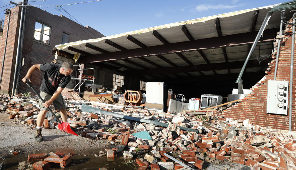 <p>Roy Schweinebart, of Marshalltown, Iowa, shovels bricks from a tornado-damaged building near Main Street, Thursday, July 19, 2018, in Marshalltown, Iowa. Several buildings were damaged by a tornado in the main business district in town including the historic courthouse. (Photo: Charlie Neibergall/AP) </p>