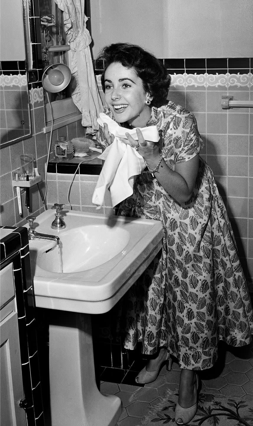 <p>A young Elizabeth appears fresh faced after washing her face. According to <a href="https://www.hollywoodreporter.com/lists/12-elizabeth-taylor-s-red-carpet-beauty-secrets-1186451/item/she-never-wore-false-eyelashes-1186495" rel="nofollow noopener" target="_blank" data-ylk="slk:an interview with her former personal assistant;elm:context_link;itc:0;sec:content-canvas" class="link ">an interview with her former personal assistant</a>, Tim Mendelson, Elizabeth was a fan of drugstore brands and incorporated affordable creams like Jergens into her routine: "She put cream on but she didn't use fancy brands," he said.<br></p>