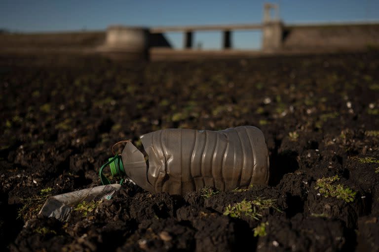 Una botella de plástico yace sobre tierra agrietada en el embalse Paso Severino en medio de una grave sequía en Florida, Uruguay, el 28 de junio de 2023. 