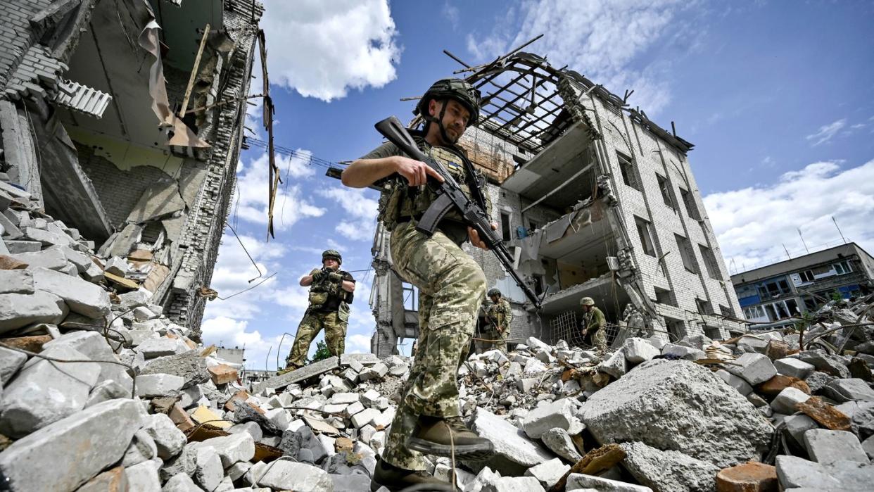Ukraine: Kämpfer des 53. Bataillons der 141. separaten Infanteriebrigade, der in der Region dienen, steigen über Trümmer eines Hauses hinweg. (Bild: dpa)