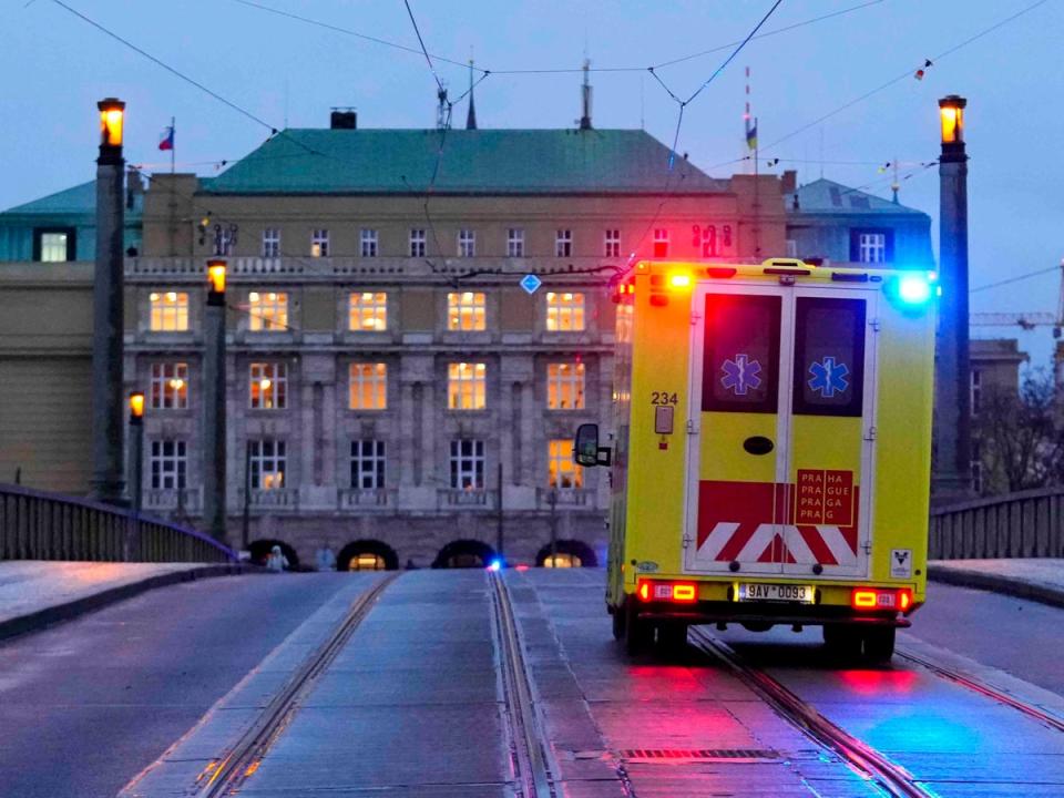 An ambulance drives towards the building of Philosophical Faculty of Charles University in Prague (AP)