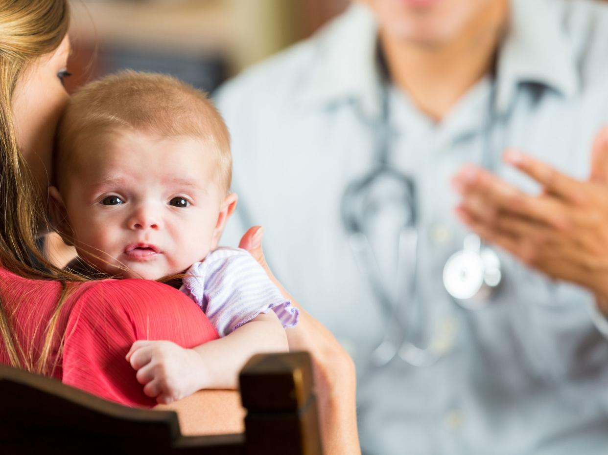 Mother holding baby with cystic fibrosis during pediatric appointment