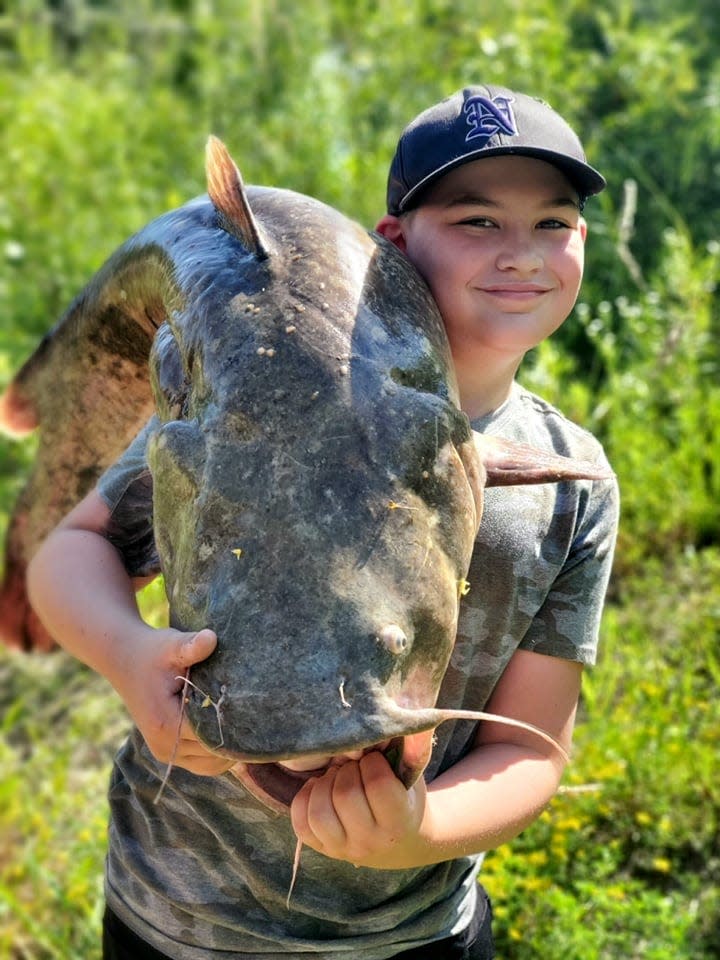 Corbin Jeffries, 10, of Norwalk shows off the 35-pound flathead catfish he caught in June 2021 in the Raccoon River.