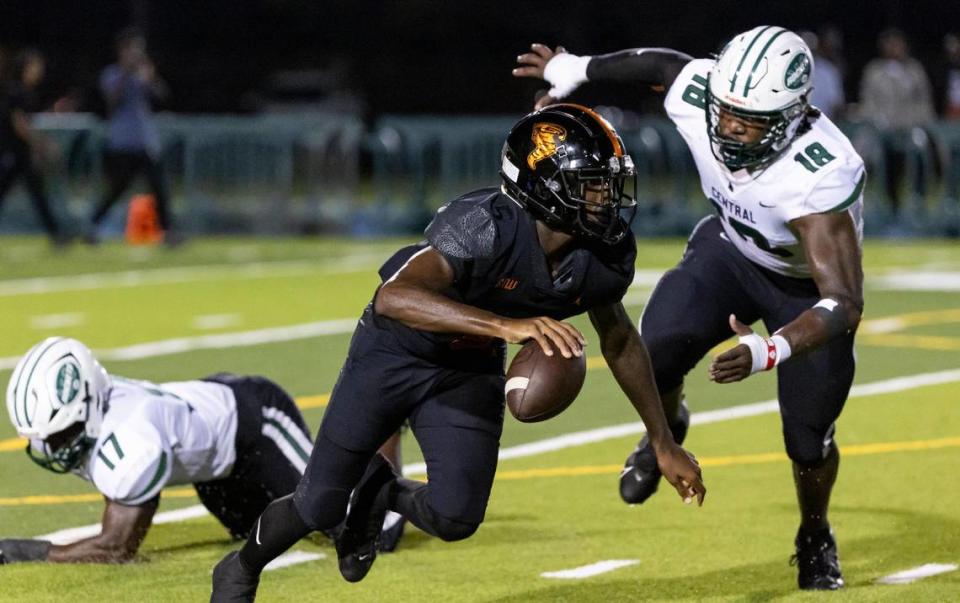 Booker T. Washington Tornadoes quarterback Claudell Sherman (5) runs with the ball as Central Rockets defensive line Armondo Blount (18) tries to tackle him during the second quarter of their high school football game at the Nathaniel Traz Powell Stadium on Friday, Sept. 8, 2023, in Miami, Fla.