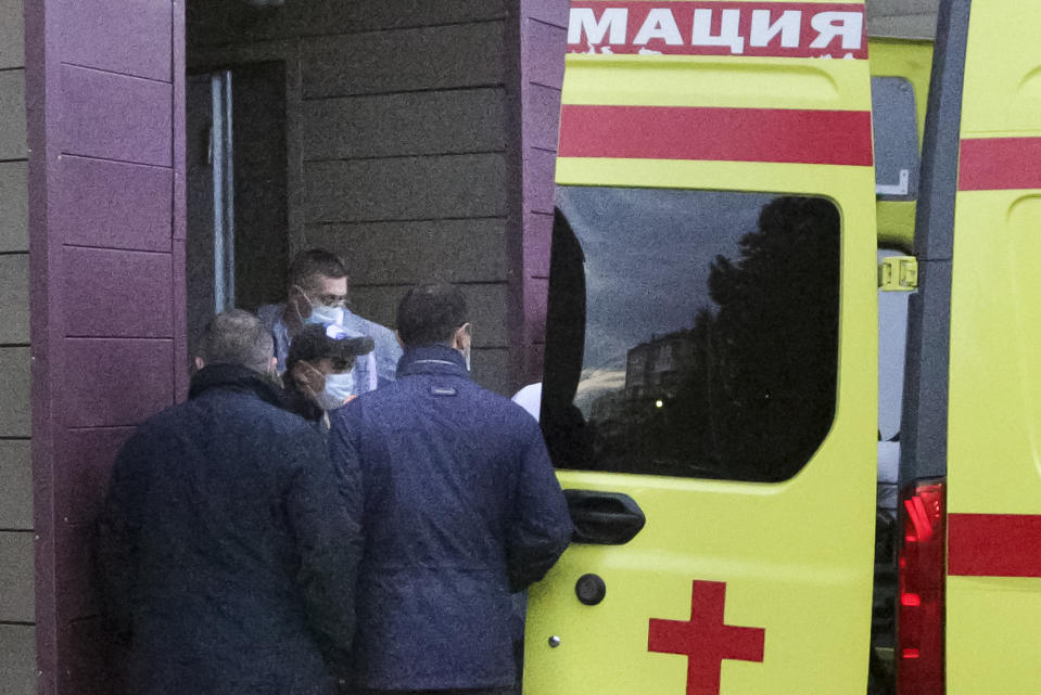Russian dissident Alexei Navalny, not seen in photo, on a stretcher is transferred into an ambulance before being driven to an airport, at the Omsk Ambulance Hospital, in Omsk, Russia, Saturday, Aug. 22, 2020. A plane carrying Navalny, who is in a coma after a suspected poisoning left for a German hospital Saturday following much wrangling over his condition and treatment. (AP Photo/Evgeniy Sofiychuk)