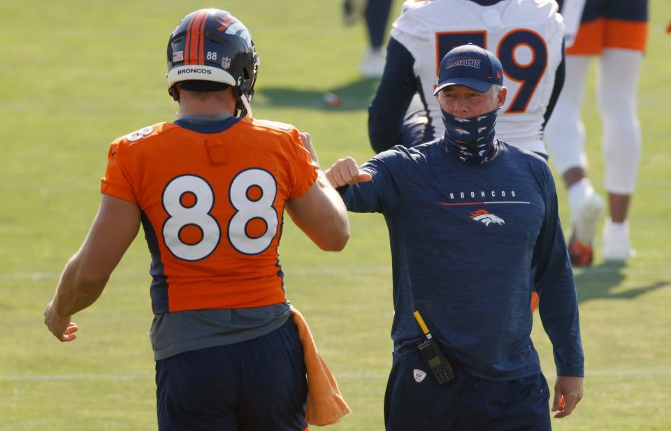 Denver Broncos tight end Nick Vannett, left, greets offensive coordinator Pat Shurmur at the team's NFL football training camp Friday, Aug. 14, 2020, in Englewood, Colo. (AP Photo/David Zalubowski)