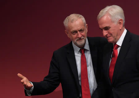 Britain's Labour party leader Jeremy Corbyn (L) reacts with Labour Party Shadow Chancellor John McDonnell on stage at the Labour Party Conference venue in Brighton, Britain, September 25, 2017. REUTERS/Toby Melville